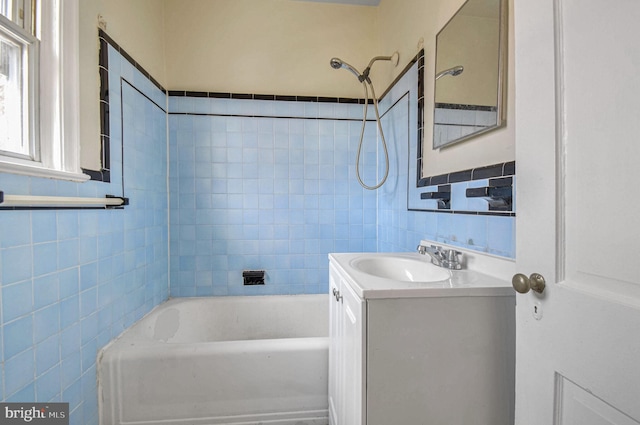 bathroom featuring vanity, tile walls, and shower / bathing tub combination