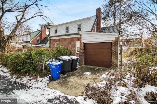 view of snow covered exterior featuring a garage