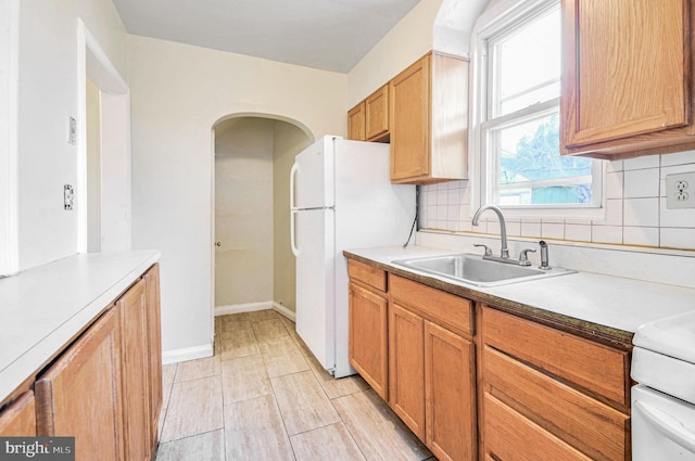 kitchen featuring white fridge, sink, and decorative backsplash