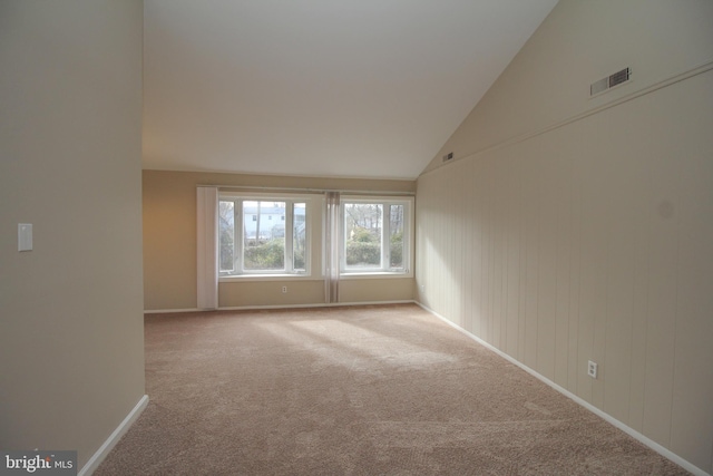 unfurnished room with carpet flooring and vaulted ceiling