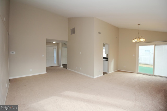 empty room with lofted ceiling, light carpet, and a chandelier