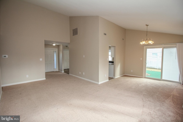 carpeted spare room with a chandelier and high vaulted ceiling