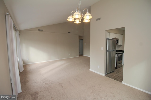 unfurnished room featuring carpet floors, high vaulted ceiling, and a notable chandelier