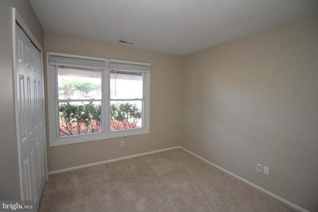 unfurnished room with light colored carpet