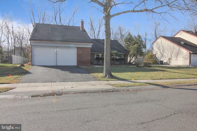 view of front of house with a garage and a front lawn