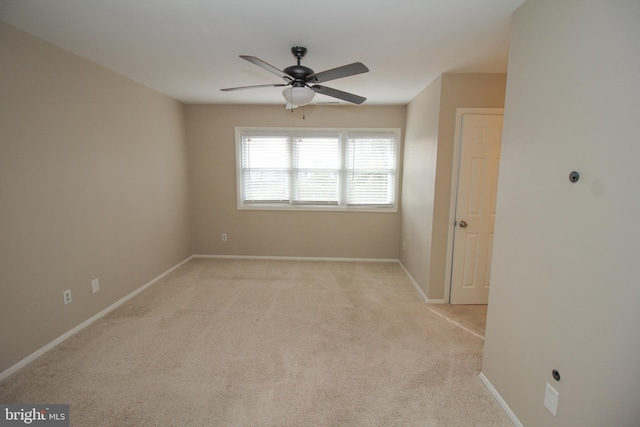 unfurnished room featuring light carpet and ceiling fan