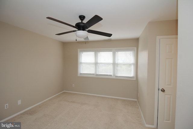 carpeted spare room featuring ceiling fan