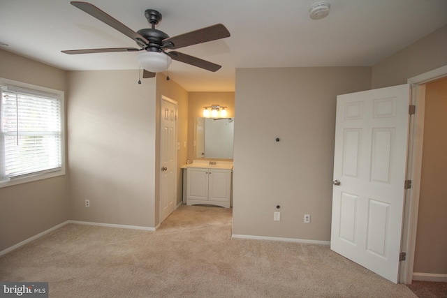 unfurnished bedroom featuring ensuite bathroom, ceiling fan, and light colored carpet