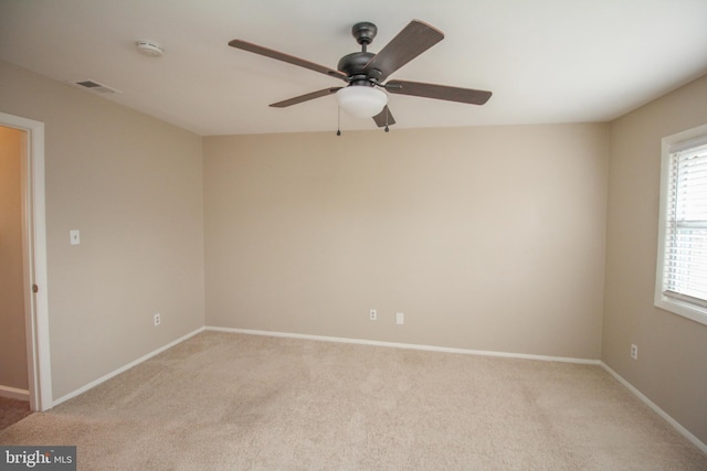 empty room featuring ceiling fan and light colored carpet