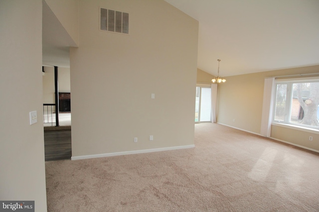 unfurnished room with light carpet, a chandelier, and high vaulted ceiling