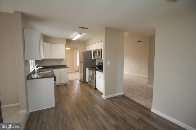 kitchen with dark wood-type flooring, white cabinetry, sink, and stainless steel appliances