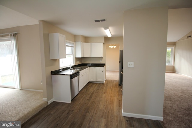 kitchen with dark colored carpet, white cabinets, a healthy amount of sunlight, and appliances with stainless steel finishes