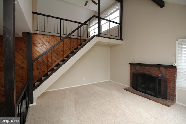 unfurnished living room featuring carpet, high vaulted ceiling, and plenty of natural light