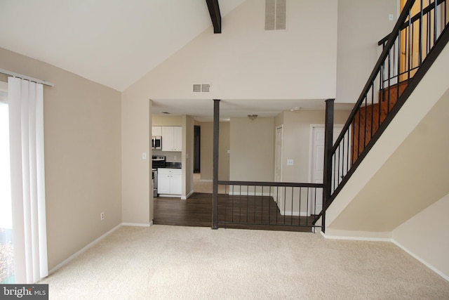 stairway featuring beam ceiling, carpet floors, and high vaulted ceiling