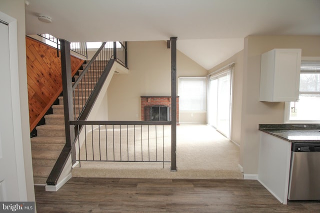 kitchen featuring dishwasher, white cabinets, a brick fireplace, and a healthy amount of sunlight