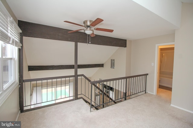 interior space with carpet, vaulted ceiling with beams, and a healthy amount of sunlight