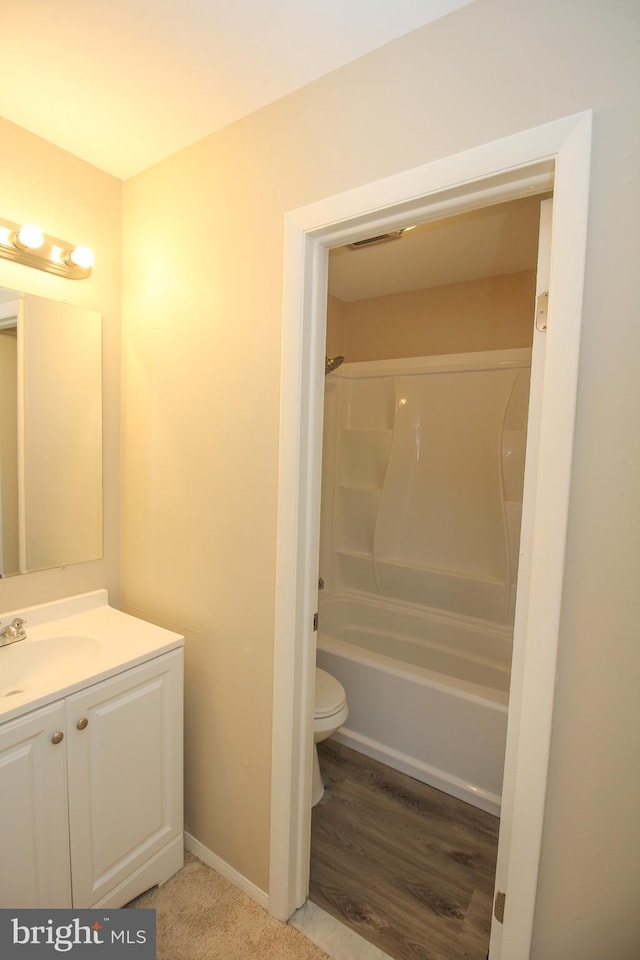 full bathroom with hardwood / wood-style flooring, vanity, toilet, and tub / shower combination