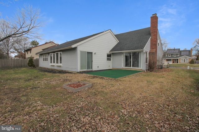 back of property with a patio area and a yard