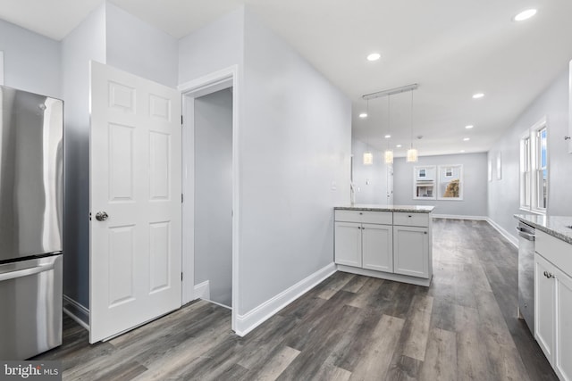 kitchen with stainless steel appliances, light stone countertops, white cabinets, decorative light fixtures, and dark hardwood / wood-style floors