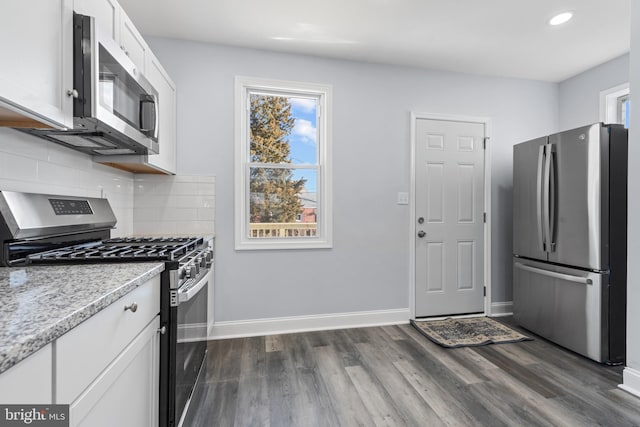 kitchen with white cabinets, appliances with stainless steel finishes, plenty of natural light, and backsplash