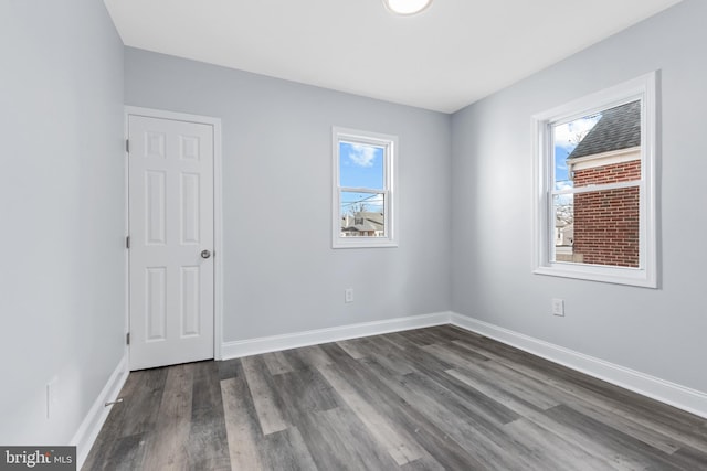 unfurnished room with dark wood-type flooring