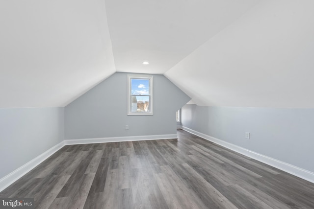 bonus room with dark hardwood / wood-style flooring and vaulted ceiling