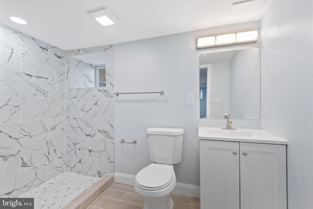 bathroom featuring vanity, tiled shower, and toilet