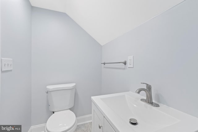 bathroom featuring lofted ceiling, vanity, and toilet