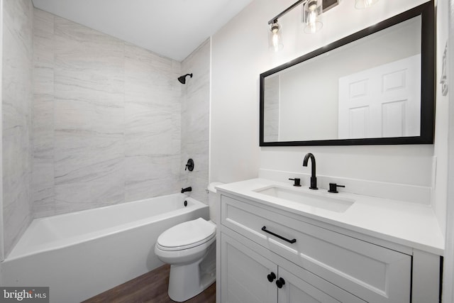 full bathroom with toilet, vanity, tiled shower / bath combo, and hardwood / wood-style floors