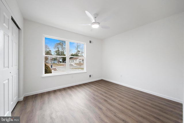 unfurnished bedroom featuring ceiling fan, dark hardwood / wood-style flooring, and a closet