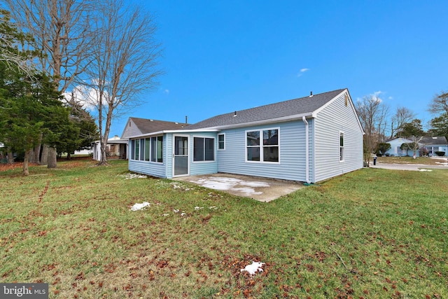 back of property with a patio area, a lawn, and a sunroom