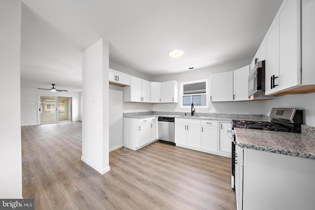 kitchen featuring light stone counters, light hardwood / wood-style flooring, stainless steel appliances, white cabinetry, and ceiling fan