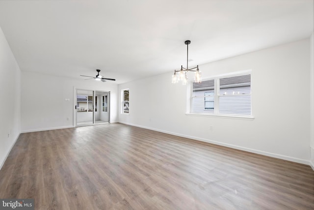 unfurnished living room featuring ceiling fan with notable chandelier and hardwood / wood-style flooring