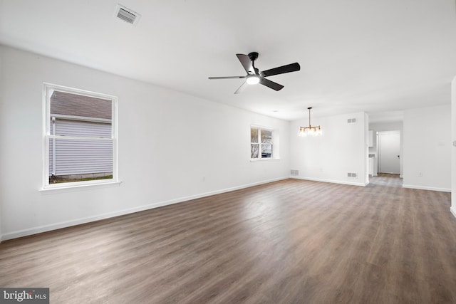 unfurnished living room with ceiling fan with notable chandelier and wood-type flooring