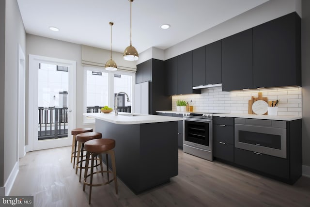 kitchen with built in microwave, electric range, tasteful backsplash, pendant lighting, and a center island with sink