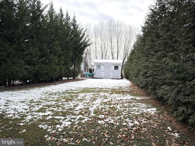 yard layered in snow featuring a storage unit