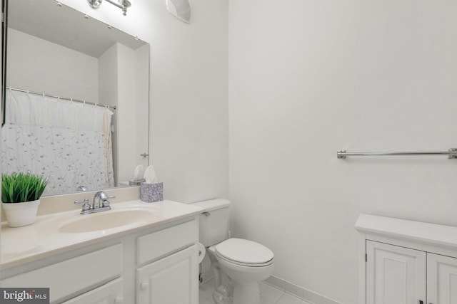 bathroom featuring tile patterned flooring, vanity, and toilet