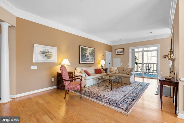 living room featuring crown molding, light wood-type flooring, and ornate columns