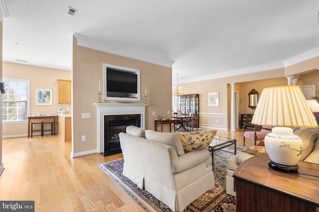 living room featuring a premium fireplace, ornamental molding, and light hardwood / wood-style flooring