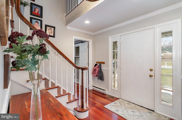 foyer with baseboard heating, ornamental molding, and hardwood / wood-style flooring