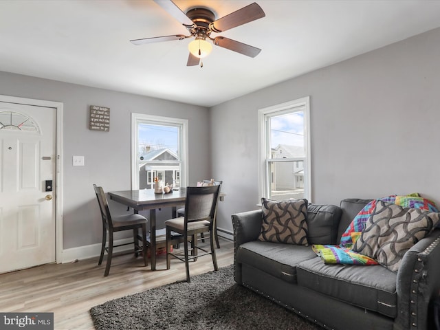 living room with ceiling fan, a wealth of natural light, and light hardwood / wood-style flooring