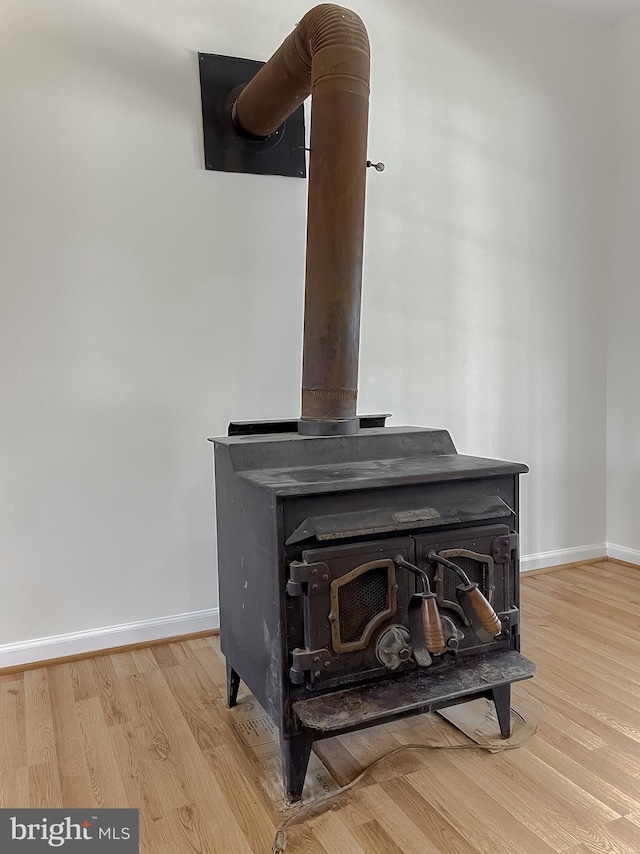 interior details with a wood stove and hardwood / wood-style floors