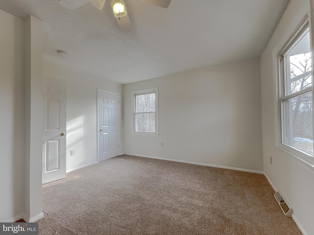 carpeted spare room featuring ceiling fan