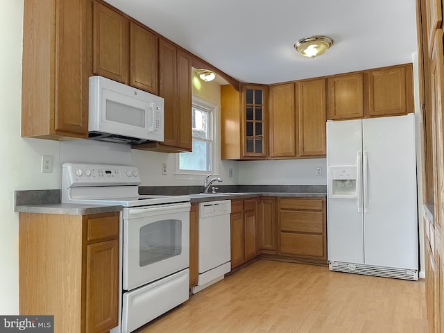 kitchen featuring light wood-type flooring, sink, and white appliances