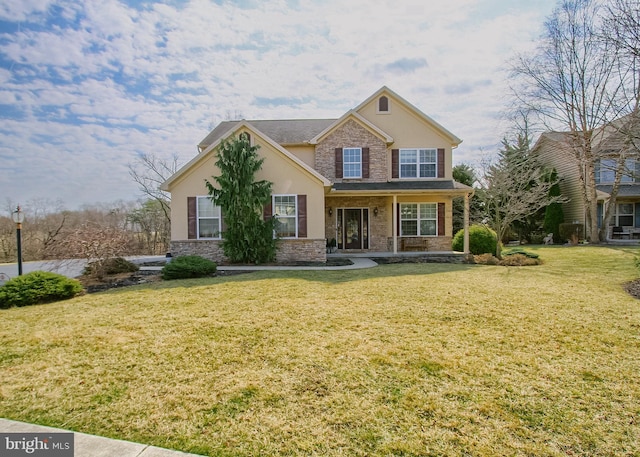 view of front of property featuring a front lawn, stone siding, and stucco siding