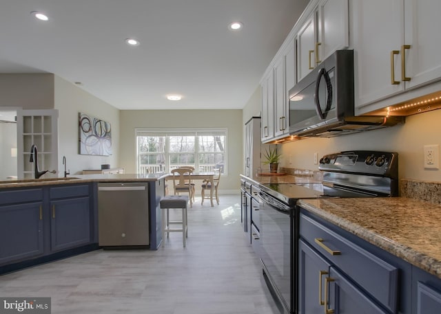 kitchen with black electric range, blue cabinetry, a sink, stainless steel dishwasher, and recessed lighting