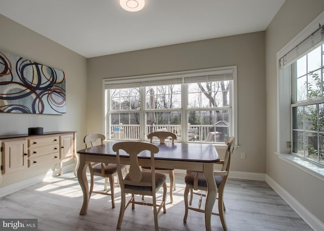 dining space with baseboards and wood finished floors