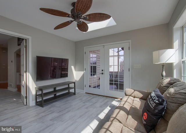 living area with french doors, baseboards, wood finished floors, and a ceiling fan