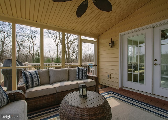 sunroom featuring wooden ceiling, a ceiling fan, and vaulted ceiling