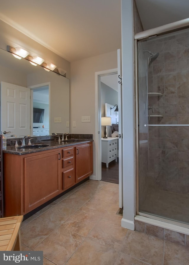 full bathroom featuring double vanity, a stall shower, and a sink